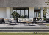Sfeerfoto van de Apple Bee Condor lounge koffietafel, stijlvol gepresenteerd op een terras, het perfecte middelpunt voor elke buitenruimte.